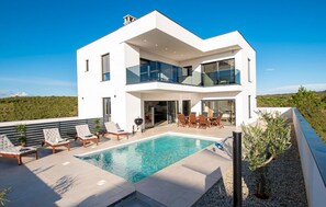 A modern two-story house with a swimming pool, outdoor furniture, and a view of the landscape. - Gorgeous home in Medulin (Medulin)