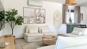 A modern living room with a sofa set, a round coffee table, and a large plant. - Gorgeous home in Medulin (Medulin)