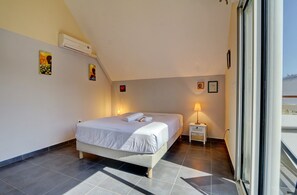 Ein Schlafzimmer mit einem Bett, Nachttischlampen und einem Fenster.