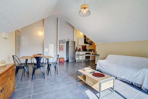 Eine Loft-Wohnung mit Essbereich, Küchenzeile und Wohnbereich mit einer Couch.