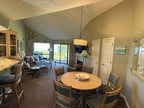 A spacious living area with a dining table, chairs, a sofa, and a fireplace. - Accessible North Bluff Open Floorplan-Ocean View (Aptos)