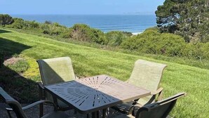 Ein Tisch mit Stühlen im Freien und Blick auf das Meer.