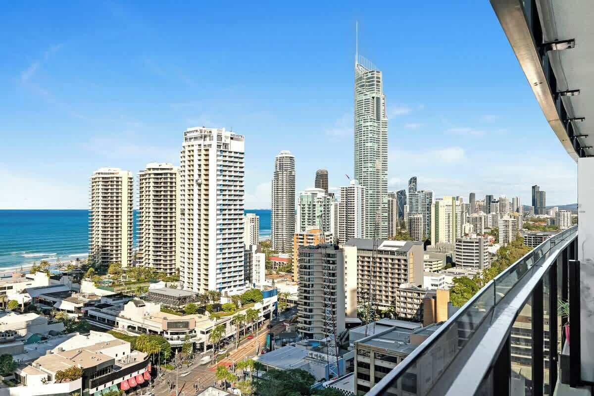 A cityscape with high-rise buildings, a prominent skyscraper, and a view of the ocean.
