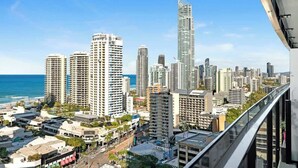 Paisagem urbana com edifícios altos, um arranha-céu imponente e vista para o oceano.