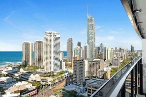 A cityscape with high-rise buildings, a prominent skyscraper, and a view of the ocean. - Steps to Cavill Ave | Ocean View 2BR | 3 Pools (Surfers Paradise)