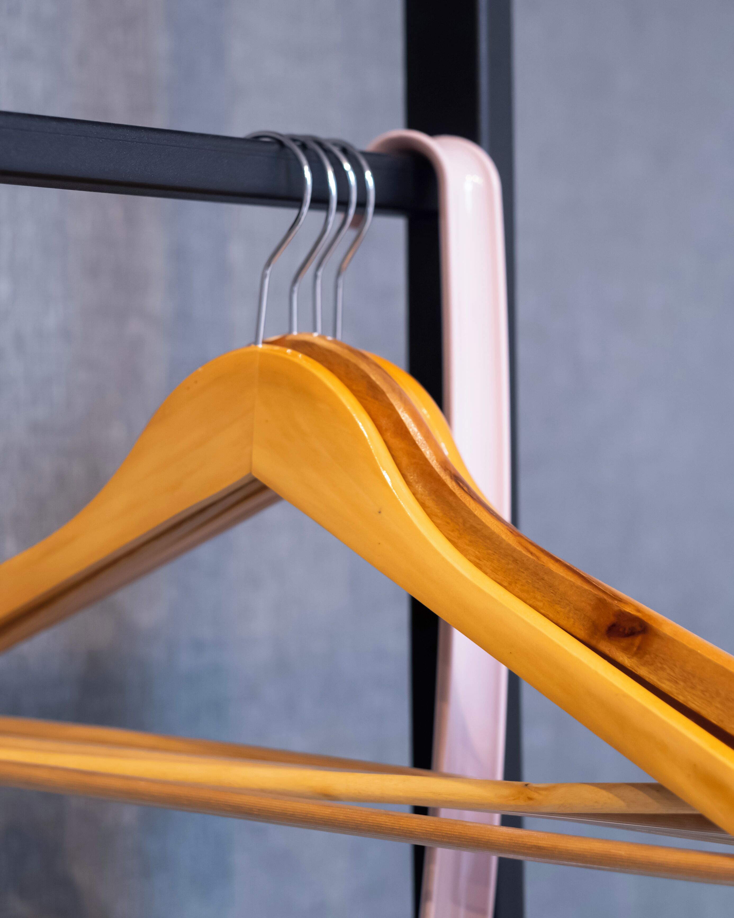 Un cintre en bois sur un porte-manteaux en métal.