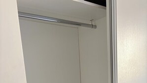 Ett rum med en vit dörr, ett svart föremål på golvet och en metallstång i taket.