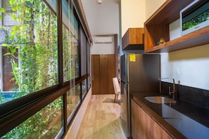 Eine moderne Küche mit einem großen Fenster, einer integrierten Spüle und einem Holzkorpus.