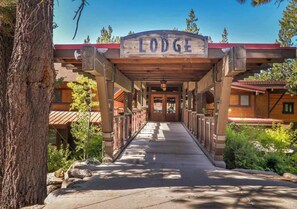A lodge entrance with a covered walkway, wooden beams, and a sign above. - Ski Slope Views Tahoe Donner Retreat (Truckee)