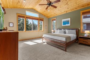 A bedroom with a wooden ceiling, large windows, a bed, a nightstand, and a desk. - Ski Slope Views Tahoe Donner Retreat (Truckee)