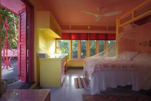 Ein Schlafzimmer mit Bett, Schreibtisch, Stuhl, Fenster und Tür.