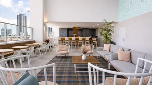 Un espace lounge moderne avec des sièges, un bar et une vue sur la ville.