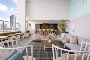 A modern lounge area with seating, a bar, and a city view. - Luxury Miami Stay with Skyline Balcony (Miami)