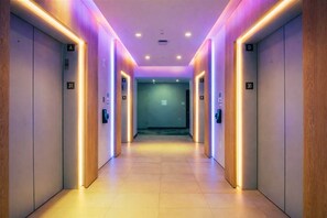 A corridor with wooden paneling, numbered doors, and a tiled floor. - Luxury Miami Stay with Skyline Balcony (Miami)