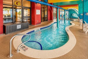 An indoor pool with a no diving sign, a safety sign, and a poolside area with a restaurant. - Oceanfront Suite • Balcony • Pools • Monterey Bay (Myrtle Beach)