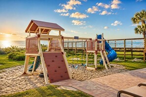 A beachside playground with a slide, climbing wall, and a small shelter. - Oceanfront Suite • Balcony • Pools • Monterey Bay (Myrtle Beach)