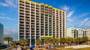 Et hotel med flere etager, altaner, legeplads og poolområde.