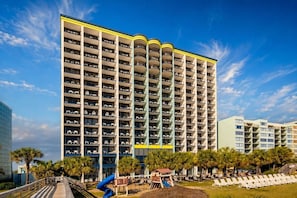 A multi-story hotel with balconies, a playground, and a pool area. - Oceanfront Suite • Balcony • Pools • Monterey Bay (Myrtle Beach)