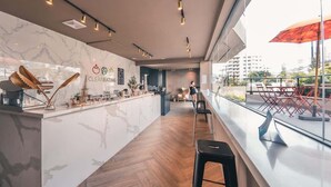 A modern bar area with a marble countertop, stools, and a view of the city through large windows. - AEA- Calle Victor Garrido Puello (Santo Domingo,)