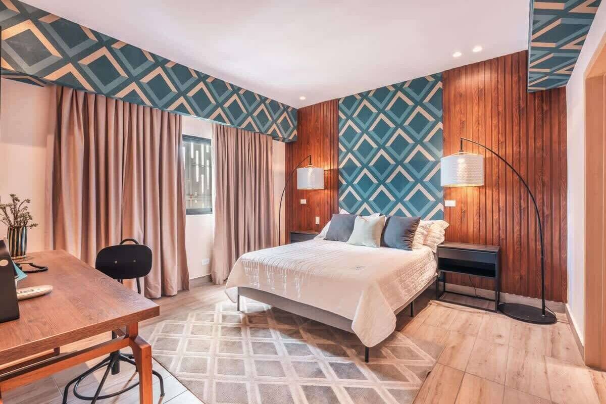 Ein modernes Schlafzimmer mit Bett, Nachttischen, Schreibtisch und Stuhl.