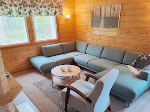 A cozy corner with a sectional sofa, a small round table, and a wall-mounted light fixture.