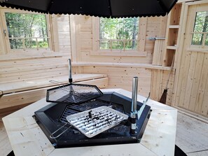 A wooden cabin with a grill area, benches, and large windows. - Keselmäkulma by Interhome (Salla)
