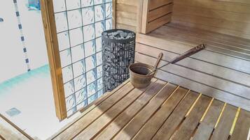 Interior de madeira com piso de esteira de tatame, um quarto em estilo tradicional japonês, parede com padrão preto e branco e um pequeno balde de madeira com concha.