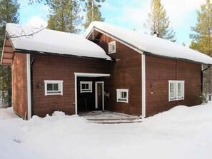 A wooden cabin with a snow-covered roof and a front door. - Keselmäkulma by Interhome (Salla)