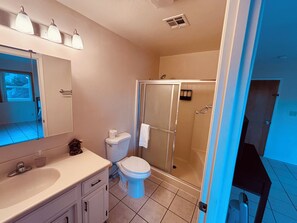 Un baño con inodoro, lavamanos y ducha.