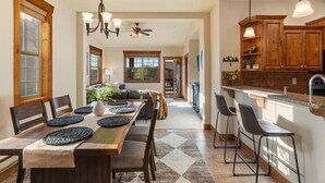 A spacious kitchen with a central island, wooden cabinets, and pendant lighting.