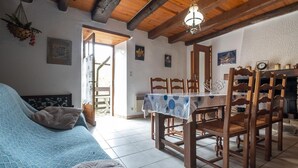 Quarto com cama, mesa de jantar com cadeiras, luminária pendente e lareira.