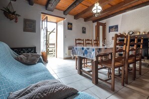 Ein Zimmer mit einem Bett, einem Esstisch mit Stühlen, einer Hängelampe und einem Kamin.