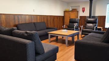 A room with a sofa, a chair, a table, and a cabinet.