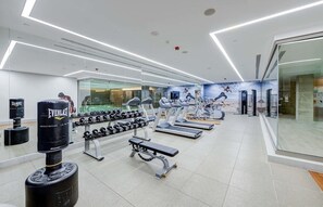 Ein modernes Fitnessstudio mit Laufbändern, Hanteln und einem Boxsack.