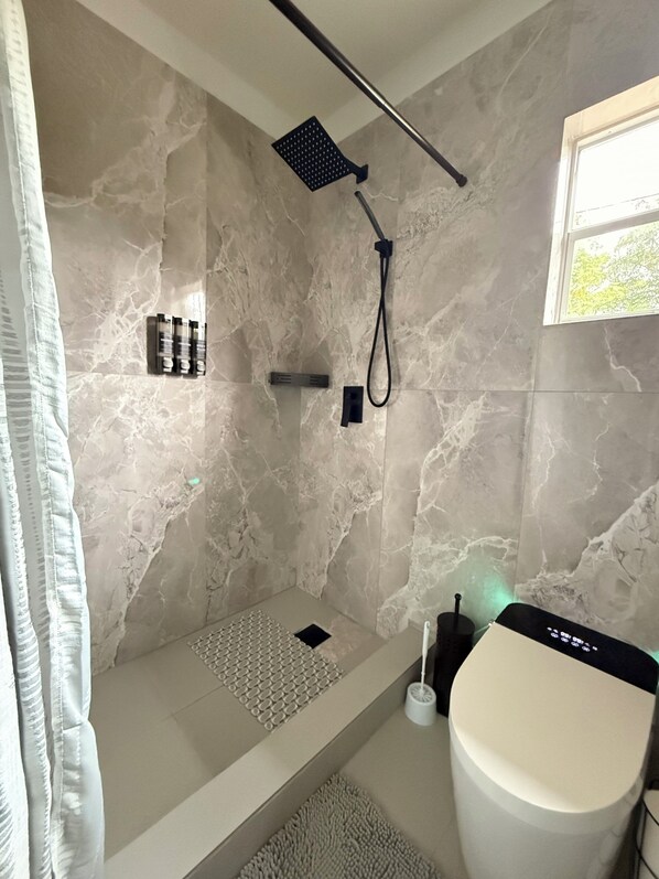 Une salle de bain moderne équipée d’une douche, de toilettes et d’un lavabo.