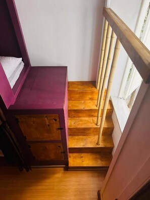 A wooden staircase with a wooden handrail and a purple wall. - Cocos Hostel Rio (Rio de Janeiro)