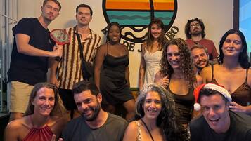 Eine Gruppe von Personen vor einer Wand mit einem Logo, auf dem 'Cocos Hostel' steht.