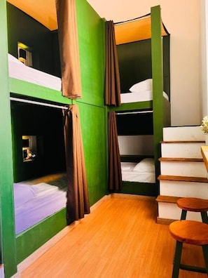 A room with bunk beds, a small table, and a staircase. - Cocos Hostel Rio (Rio de Janeiro)