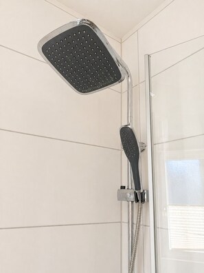 A shower with a square head and a handheld control.