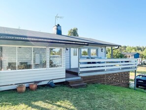 A single-story house with a covered porch, large windows, and a chimney. - 7 Person Holiday Home in Monsteras (Monsteras)