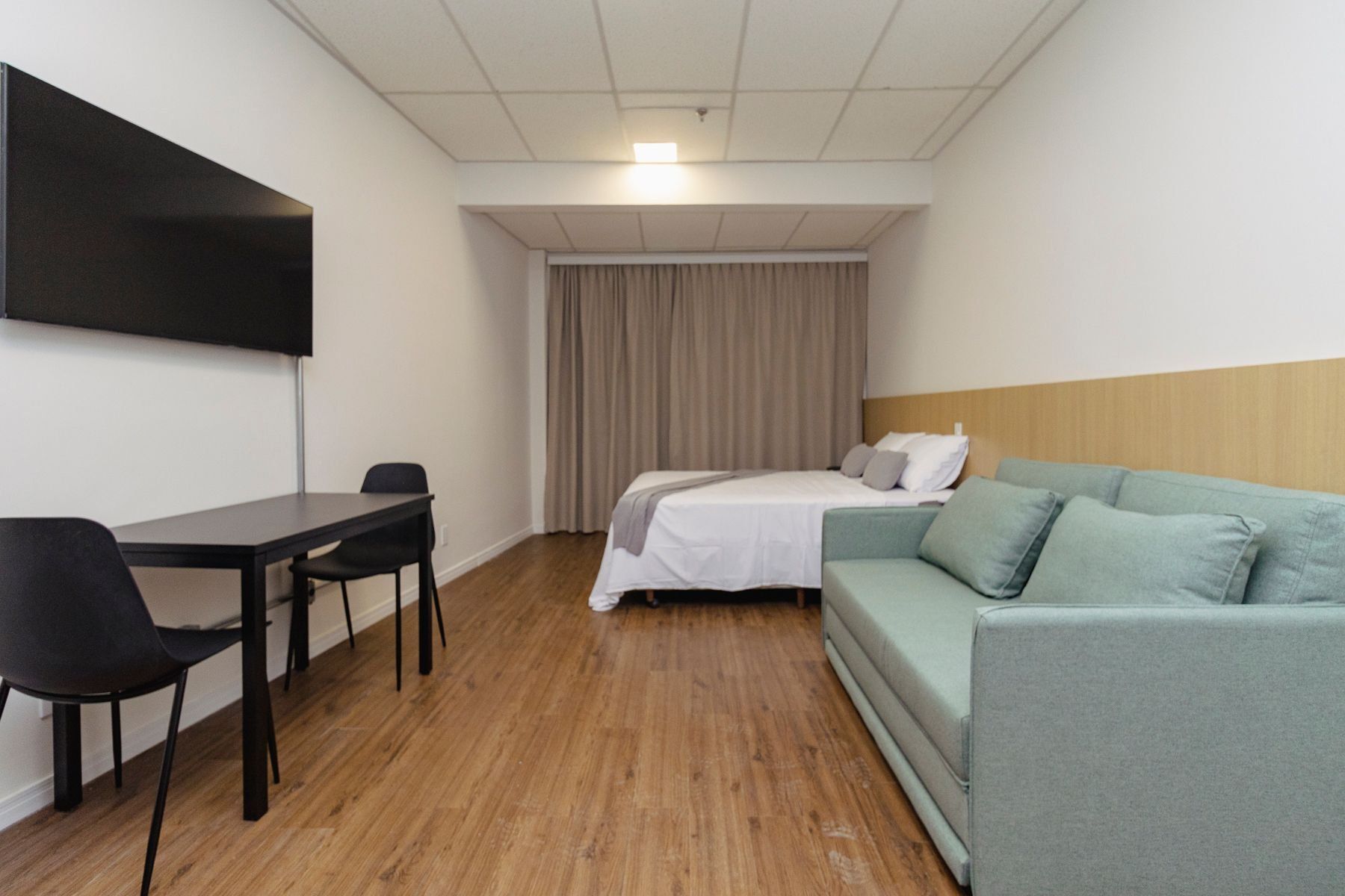Habitació d'hotel amb llit, sofà, escriptori i cadira.