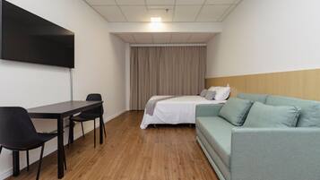 Habitació d'hotel amb llit, sofà, escriptori i cadira.