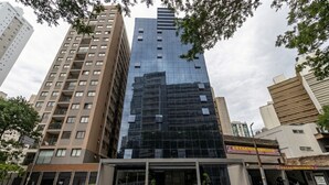 A modern high-rise building with a glass facade, surrounded by other buildings and trees. - Belong Stay Martins Fontes by Unna (São Paulo)