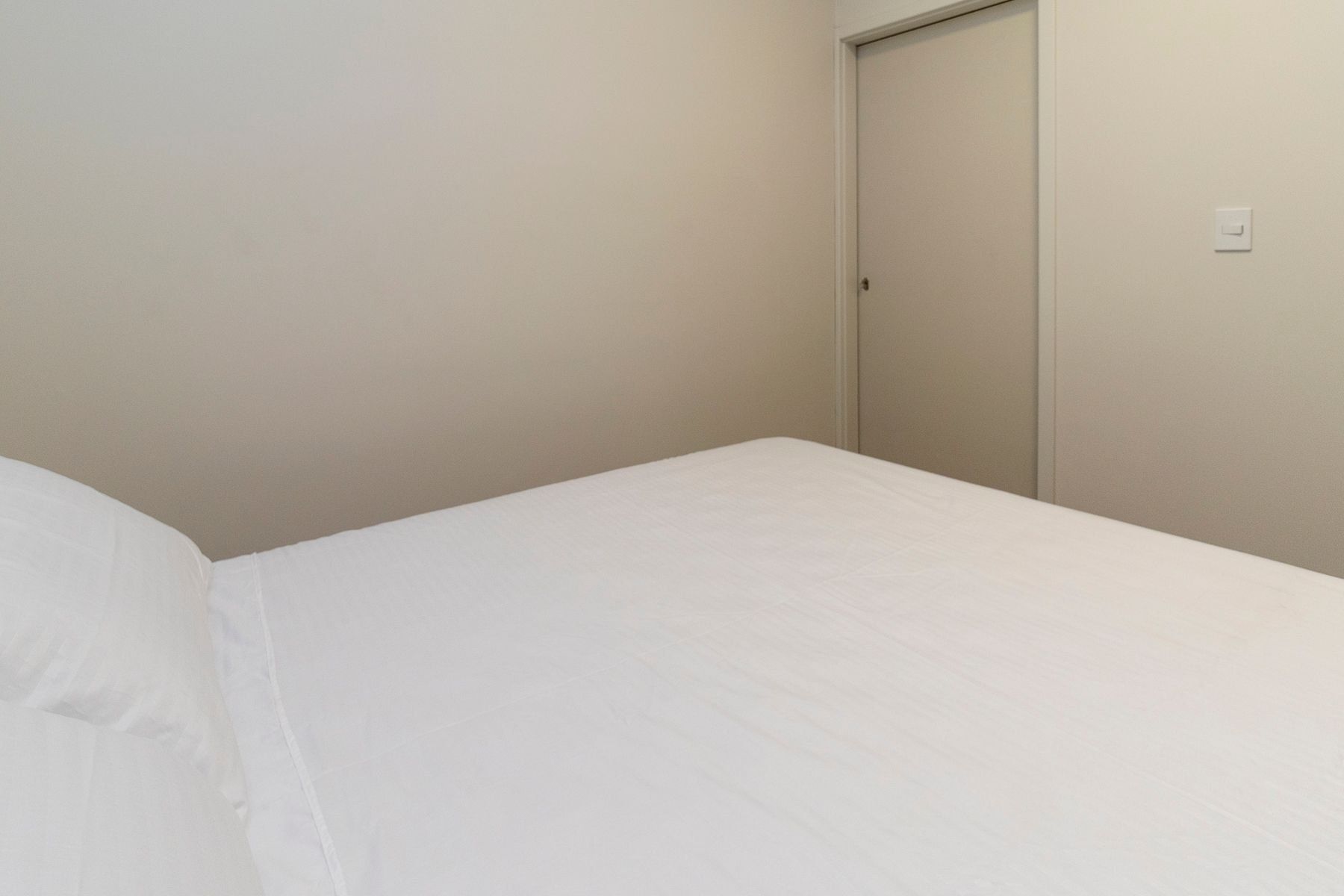 A simple room with a bed and a closed door.
