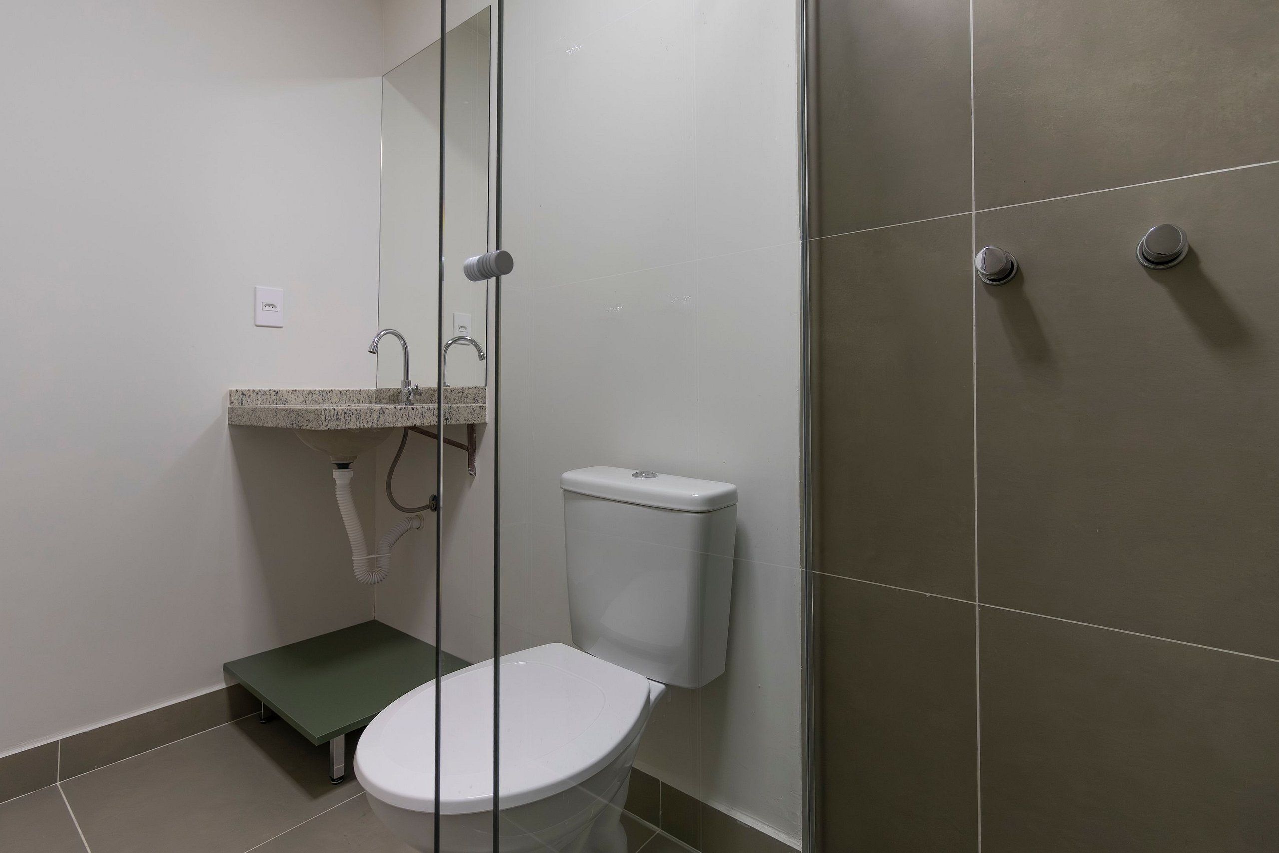 Un baño con inodoro, lavamanos y zona de ducha.