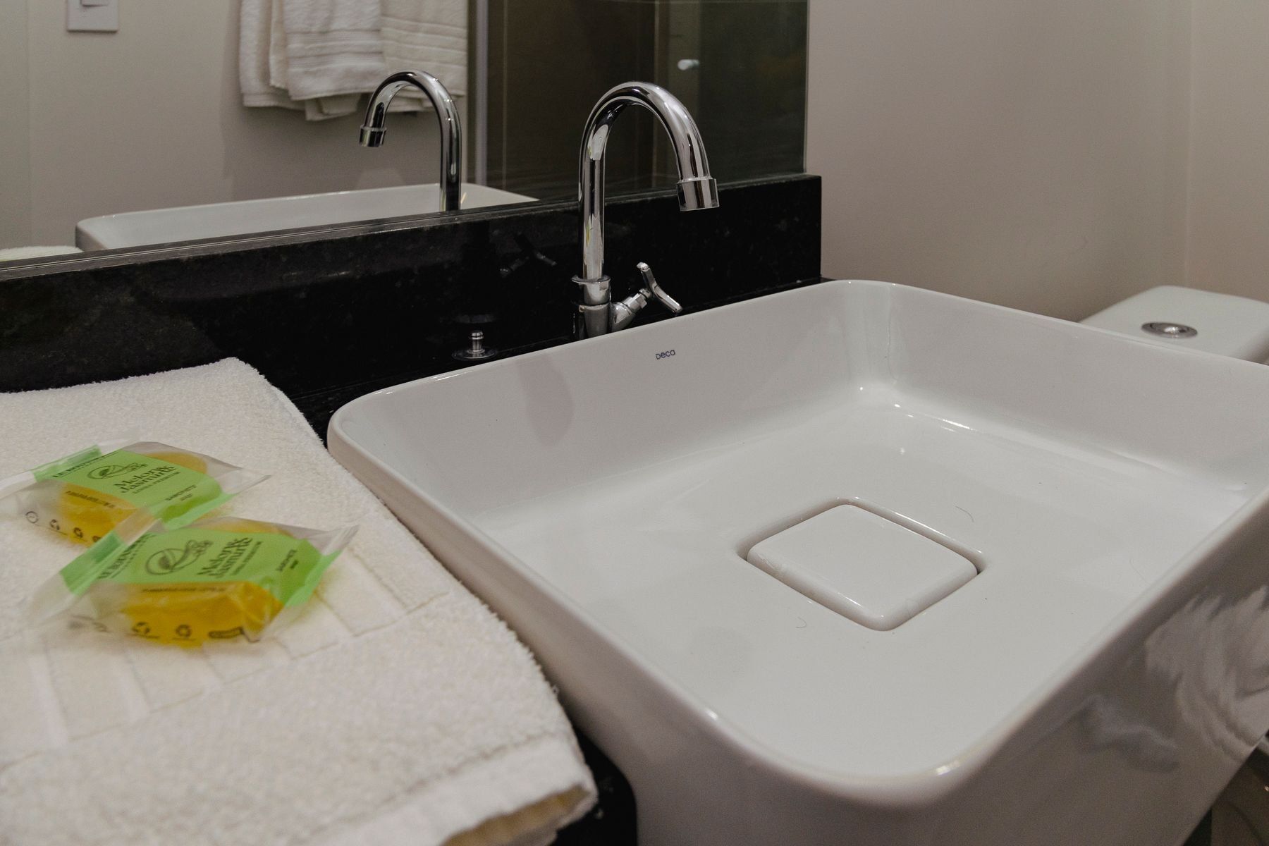 Une salle de bain avec un lavabo blanc, un miroir et une serviette.