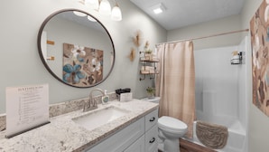 A bathroom with a marble sink, a toilet, a shower, and a large mirror. - Relaxing 2BR 1BA Townhome • Loaded Amenities • Central Location Near I-40 (Jackson)