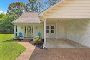 A single-story house with a covered porch, a front door, and a garage door.