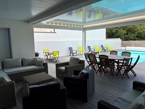 An outdoor patio with wicker furniture, a pool, and chairs. - Villa Marthe Océane - Bretignolles sur mer (BRETIGNOLLES SUR MER)