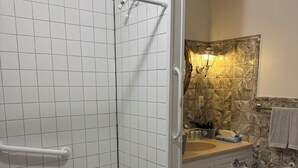 Un bagno con doccia, toilette, lavandino e una decorazione a parete.